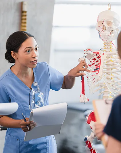 a medical professional gestures to a skeleton