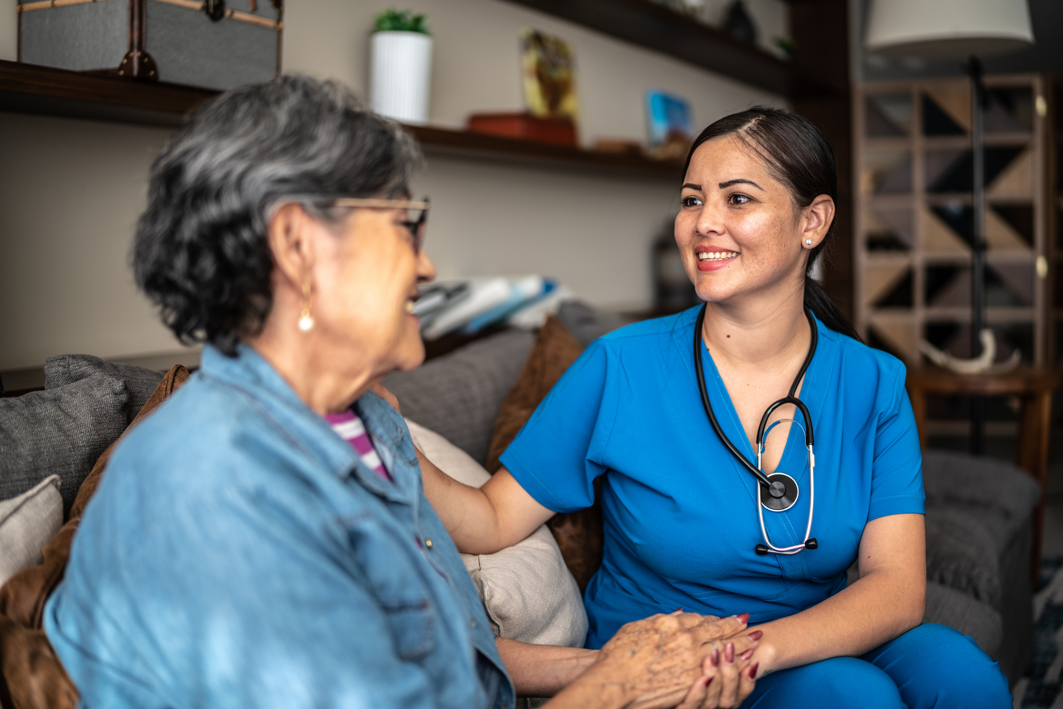 A home health nurse meets with a patient in the patient’s home.